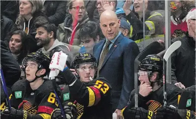  ?? DARRYL DYCK THE CANADIAN PRESS ?? Canucks head coach Rick Tocchet stands behind, from left, Ilya Mikheyev, Bo Horvat and Brock Boeser during the first period against the Chicago Blackhawks in Vancouver on Tuesday. Tocchet has replaced the recently fired Bruce Boudreau.