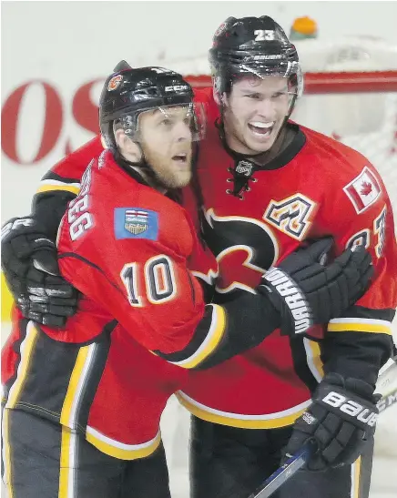  ?? LEAH HENNEL/POSTMEDIA ?? Kris Versteeg, left, celebrates Sean Monahan’s goal against Columbus on Friday night in Calgary. The Flames lost 4-1 but Monahan extended his points streak to nine games.