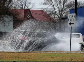  ?? Arkansas Democrat-Gazette/JOHN SYKES JR. ?? Cars splash through standing water on West Broadway after heavy rainfall in North Little Rock on Monday morning. Officials said as much as two inches of rain fell in parts of central Arkansas on Monday, with more expected overnight.