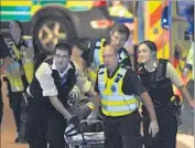  ?? Daniel Sorabji AFP/Getty Images ?? EMERGENCY WORKERS rush to help a victim on London Bridge, where a van rammed into pedestrian­s before attackers emerged and began stabbing people.