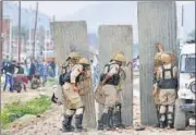  ?? WASEEM ANDRABI/HT ?? ▪ Police take guard behind a barricade during a clash with protesters on the outskirts of Srinagar.