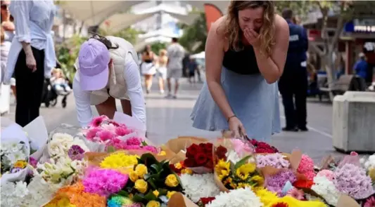  ?? ?? ▲ People react as they leave flowers outside the Westfield Bondi Junction shopping mall in Sydney on April 14, 2024, the day after a 40-year-old knifeman with mental illness roamed the packed shopping centre killing six people and seriously wounding a dozen others.