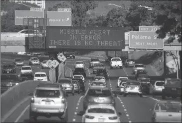  ?? The Associated Press ?? MISSILE ERROR: In this photo provided by Civil Beat, cars drive past a highway sign that says “MISSILE ALERT ERROR THERE IS NO THREAT” on the H-1 Freeway on Saturday in Honolulu. The state emergency officials announced human error as cause for a...