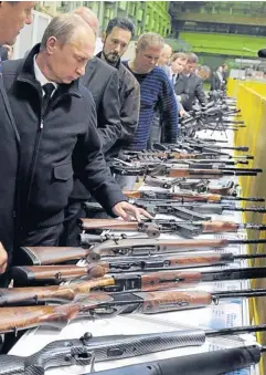  ??  ?? Russian President Vladimir Putin, left, looks at guns at the Izhevsk Machine Works factory in Izhevsk, Russia on Sept 18, 2013.