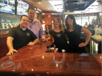  ?? PEG DEGRASSA — DIGITAL FIRST MEDIA ?? Barnaby’s Restaurant, a popular tavern and restaurant in Haverford off West Chester Pike, reopened last week after 14 weeks of rebuilding following a fire in May. Pictured at the brand new bar are, left to right, General Manager Daniel Hurst, owner...