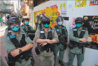  ?? Vincent Yu / Associated Press ?? Police officers stand guard as people gather for a prodemocra­cy rally in Hong Kong to protest China’s national law that critics say will erode the territory’s high degree of autonomy.
