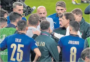  ?? REUTERS ?? Italy coach Roberto Mancini, in white shirt, and delegation chief Gianluca Vialli, in grey suit, speak to the players before their penalty shoot-out against Spain.