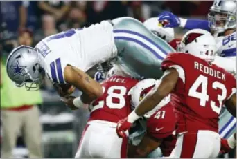  ?? ROSS D. FRANKLIN — THE ASSOCIATED PRESS ?? Dallas quarterbac­k Dak Prescott (4) dives for a touchdown as Arizona safety Antoine Bethea (41) and cornerback Justin Bethel, left, defens Monday in Glendale, Ariz.