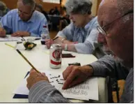  ?? Arkansas Democrat-Gazette/THOMAS METTHE ?? Competitor­s David Miller (from left), Sharum Dinning and Garrett McAinsh fill out crossword puzzles during the Arkansas Puzzle Day Competitio­n on Sunday, part of the Arkansas Literary Festival in Little Rock.