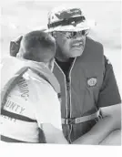  ??  ?? Annapolis police Sgt. Jimmy Spearman talks to the kids as they sail in the Chesapeake Bay.