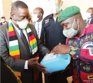  ?? — ?? President Mnangagwa and ZANU PF acting deputy secretary for Youth Affairs Tendai Chirau examine a sanitiser sample produced by the party’s youths before attending a Politburo meeting in Harare yesterday. Read story on Page 2