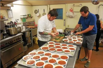  ?? PHOTOS BY VIRGINIA LINDAK — FOR DIGITAL FIRST MEDIA ?? Chef Seth Williams prepares the meal along with help from event creator, Brendan Tracy, at the annual Camphill Village Kimberton Hills “What’s For Dinner?” fundraiser.