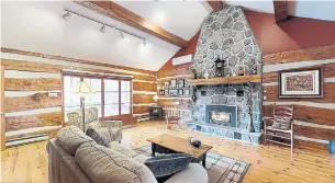  ?? COLDWELL BANKER R.M.R. REAL ESTATE PHOTOS ?? Highlights of the living (or great) room include a vaulted ceiling with wood beams and log walls.