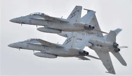  ?? PAUL CROCK/AFP/GETTY IMAGES ?? Royal Australian Air Force F-18 Hornets perform during an airshow near Melbourne in 2015. The Canadian government is looking at upgrading its fleet of CF-18s with these jets, the Australian equivalent, as a stopgap measure after it cancelled an order...