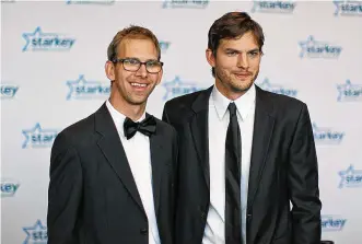  ?? ADAM BETTCHER/ GETTY IMAGES FOR STARKEY HEARING FOUNDATION/TNS ?? Michael Kutcher (left) and brother Ashton Kutcher walk the red carpet before the 2013 Starkey Hearing Foundation’s “So the World May Hear” Awards Gala on July 28, 2013, in St. Paul, Minnesota.