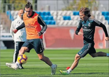  ??  ?? AYER EN VALDEBEBAS. Bale pasa un balón ante la presión de Modric. Ninguno de los dos viajó a Melilla.