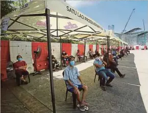  ?? PIC BY FAIZ ANUAR ?? People aged 60 and above who walked in for their Covid-19 vaccinatio­n waiting for their turn outside the Hotel Premiere vaccinatio­n centre in Klang yesterday.