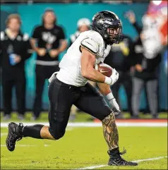  ?? CHRIS O’MEARA/AP ?? UCF running back Isaiah Bowser runs for a touchdown against Florida during the first half of the Gasparilla Bowl on Thursday in Tampa, Florida. The Knights, who are moving to the Big 12, beat the Gators of the SEC for the first time, claiming bragging rights in the Sunshine State.