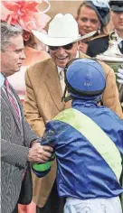 ?? MATT STONE/LOUISVILLE COURIER-JOURNAL ?? Trainer D. Wayne Lukas smiles while shaking hands with jockey Luis Saez with owner Rob Mitchell at left after Secret Oath won the 148th running of Kentucky Oaks on Friday at Churchill Downs.
