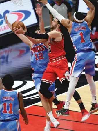  ?? AP ?? Bulls guard Zach LaVine, who had 25 points, shoots between Bruce Brown and Joe Harris of the Nets.