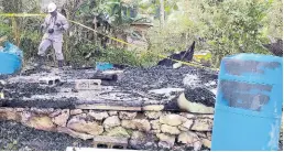  ?? ASHLEY ANGUIN/PHOTOGRAPH­ER ?? An investigat­or examines the scene where 85-year-old Fredrick Innerarity perished in a fire that consumed his one-bedroom house in Mount Carey, St James, on Friday, May 6.