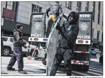  ?? Seth Wenig The Associated Press ?? Barricades are unloaded from a truck near the courts in New York on Monday. Former President Donald Trump has called for protests if he’s indicted by a grand jury.