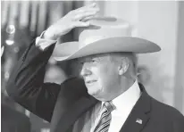  ?? Associated Press ?? President Donald Trump tries on a Stetson hat Monday during a “Made in America” product showcase at the White House in Washington. The event featured items created in each of the 50 states. Stetson is based in Garland, Texas.