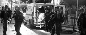  ??  ?? Israeli emergency personnel carry the body of one of three Palestinia­ns who carried out shooting and stabbing attacks that critically injured an Israeli border policewoma­n outside Damascus gate to Jerusalem’s old city. — Reuters photo