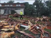  ?? RED HUBER/ORLANDO SENTINEL VIA ASSOCIATED PRESS ?? Palm Bay officer Dustin Terkoski walks over debris from a two-story home at Palm Point Subdivisio­n in Brevard County, Fla., after a tornado touched down on Sunday.