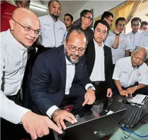  ??  ?? mcmc chairman al-ishsal Ishak (left) and Gobind (second from left) try out the high-speed broadband service after the pilot project of the NFCP in Jasin, melaka.