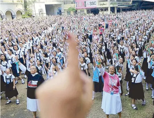  ??  ?? Students and sisters of St. Scholastic­a’s College in Manila support the One Billion Rising movement (above), led by theater actress and OBR director Monique Wilson (right).