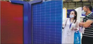  ?? PROVIDED TO CHINA DAILY ?? Visitors look at a solar panel during an industry expo in Shanghai.