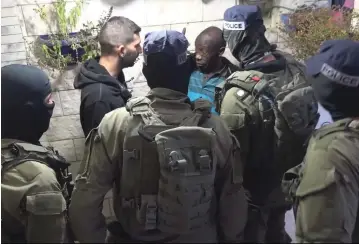  ??  ?? POLICE SPEAK to a suspect during a raid in an Arab neighborho­od earlier this week.