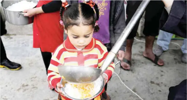  ??  ?? BAGHDAD: A displaced girl waits for donated food at Al-Takia camp in Baghdad, Iraq. More than 3 million Iraqis are displaced within the country by violence and instabilit­y. — AP