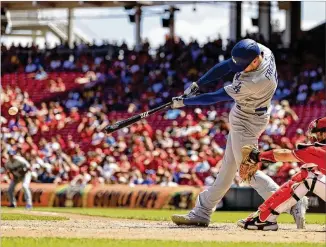  ?? AARON DOSTER / AP ?? The Los Angeles Dodgers’ Freddie Freeman hits an RBI single in the eighth inning Thursday at Great American Ball Park. Freeman homered and drove in three runs as the Dodgers won 10-5.