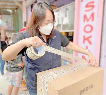  ?? PHOTOGRAPH COURTESY OF DTI ?? CONSUMER Protection Group undersecre­tary Atty. Ruth Castelo sealing unlicensed fireworks from a store in Bocaue, Bulacan.