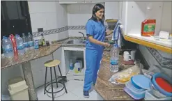  ??  ?? Ghosh cleans dishes in a temporary apartment provided by Baytna Baytak.