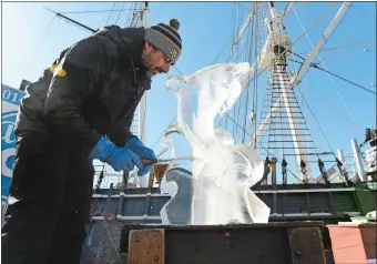  ?? DANA JENSEN/THE DAY ?? Louis Manzoni of Art in Ice in Rhode Island works Saturday on an ice sculpture of a dolphin during the Wintertide event at the Mystic Seaport Museum.