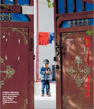  ?? AP ?? A Uighur child plays in the courtyard of a home at the Unity New Village in Hotan, in the Xinjiang province.