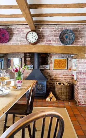  ??  ?? ‘Our home is comfortabl­e and relaxed. I’m a maximalist – I’d describe our DINING ROOM Erik limewashed the inglenook fireplace and hung two molas (embroidere­d fabric panels) from Panama inside it. The baskets were bought at TK Maxx