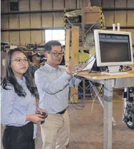  ?? FRAM DINSHAW/TRURO NEWS ?? Qilin Yu, left, and professor Young Ki Chang must constantly fine-tune their robot.
