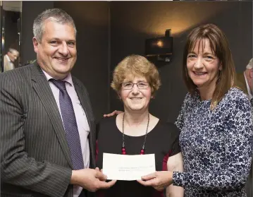  ??  ?? Colm Mulligan accepts a cheque on behalf of the Bobby Messett Fund from chairperso­n Georgina Masterson and Mary Flynn.