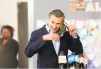  ?? Noah Berger / Special to The Chronicle ?? Gov. Gavin Newsom, seen preparing to speak at a news conference this month at Ruby Bridges Elementary School in Alameda, has crafted an incentiveb­ased plan to entice school districts to reopen, starting with the youngest students.