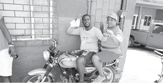  ?? RICARDO MAKYN ?? PNP and JLP supporters pose for a photo on a bike in Plowden community in Manchester during the local government elections on February 26.