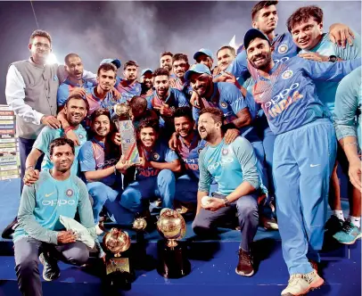  ?? —AP ?? Members of the Indian team celebrate with the trophy after defeating Bangladesh in the Nidahas triangular Twenty20 cricket series final in Colombo on Sunday. Dinesh Karthik smashed 29 runs in eight balls (two fours and three sixes) to fashion the...