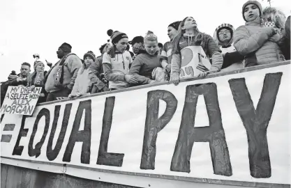  ?? JESSICA HILL/AP ?? Fans stand behind a sign promoting equal pay for the U.S. women’s soccer team during a match April 6 against Colombia in East Hartford, Conn.