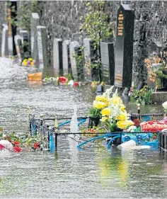  ??  ?? Graveside flowers damaged by the flooding.