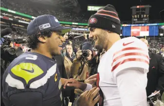  ?? Stephen Brashear / Associated Press ?? Seahawks quarterbac­k Russell Wilson, left, greets 49ers quarterbac­k Jimmy Garoppolo after the thriller. The two put on a show in a game that decided the NFC West title.