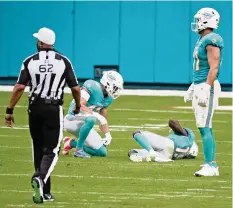  ?? CHARLES TRAINOR JR ctrainor@miamiheral­d.com ?? Jakeem Grant remains on the ground in pain after being plowed over by the Bengals’ Mike Thomas while waiting to catch a punt in the fourth quarter.