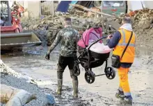  ?? /Reuters ?? Airborne: Rescuers carry a pram with a baby inside on Sunday after a landslide on the Italian island of Ischia. Three people died, and searches continue for survivors.